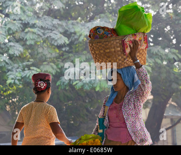 Woman carrying basket on head, Mandalay, Myanmar Stock Photo