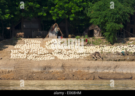 Drying handmade straw hats on the river bank of the Ayarwaddy River, Myanmar Stock Photo