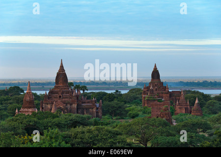 Ancient temples and pagodas in the jungle by Irrawaddy River at sunset, Bagan, Myanmar Stock Photo