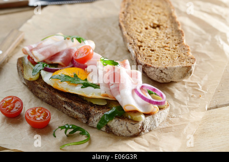 Bacon and fried egg open sandwich on the table Stock Photo