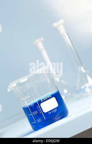 Glass beaker in laboratory filled with blue solutions Stock Photo