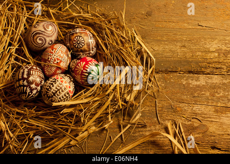 Easter eggs in nest on wooden table Stock Photo