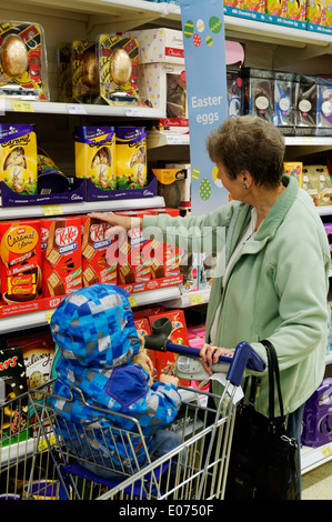 Grandmother and grandson shopping for easter eggs in Tesco Stock Photo