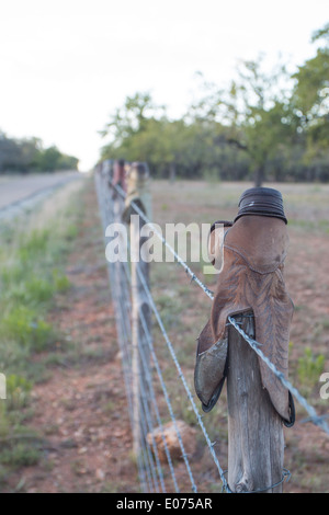 Boots on a barbed wire fence Stock Photo