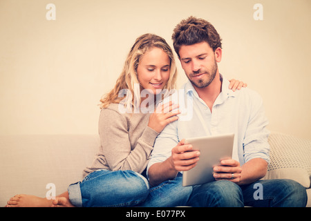 Happy young couple at home using digital tablet Stock Photo