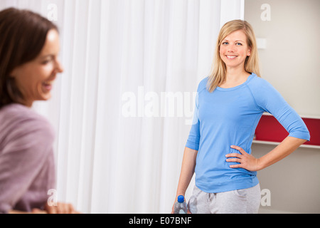 Two women taking a break from fitness training in gym Stock Photo