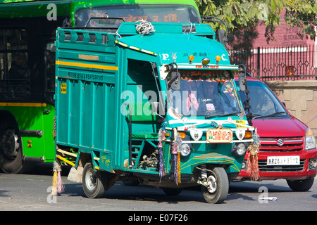 A brightly coloured Indian Dustbin Lorry, (Garbage Truck),  waits at the lights, New Delhi Street Scenes. Stock Photo