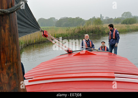 At the tiller of the historic Norfolk trading wherry Albion, sailing on the River Bure, Broads National Park Stock Photo