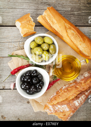 Italian food appetizer of olives, bread and spices on wooden table background Stock Photo