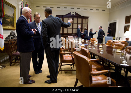 US President Barack Obama talks with Sen. Saxby Chambliss, left, and Rep. Mike Rogers, following a meeting with Members of Congress regarding intelligence programs in the Roosevelt Room of the White House January 9, 2014 in Washington, DC. Stock Photo