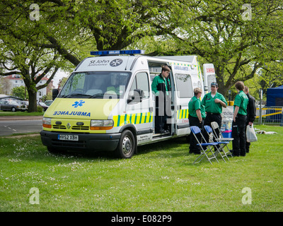 Members of St. John Ambulance providing emergency first aid cover from an ambulance at a community event. Stock Photo