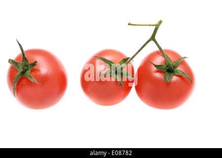Three tomatoes on a branch isolated. Cherry tomatoes. Stock Photo