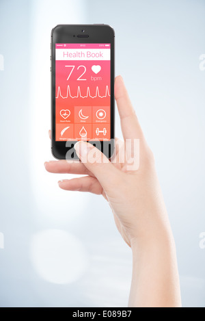 Woman hand is holding black mobile smart phone with health book app on the screen. Stock Photo
