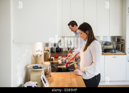 Couple preparing food together in kitchen Stock Photo