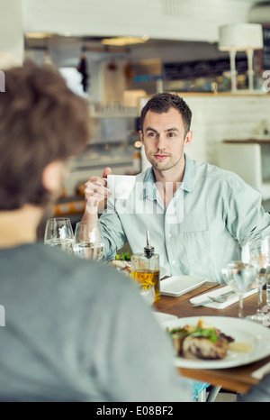 Businessman looking at colleague while having coffee in restaurant Stock Photo