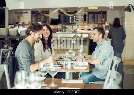 Happy friends discussing at restaurant table Stock Photo