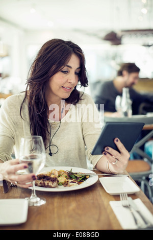 Woman using digital tablet in restaurant Stock Photo