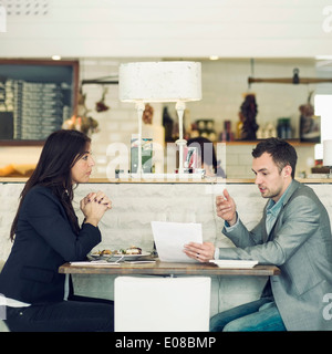 Side view of businessman with female colleague discussing at restaurant table Stock Photo