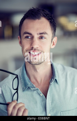 Mid adult businessman looking away while holding glasses in restaurant Stock Photo