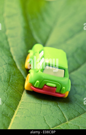 small green toy car on a leaf, green car concept Stock Photo