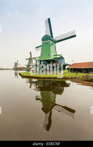 GREEN WINDMILL AND TWO OTHERS ON THE CANAL AT ZAANSE SCHANS  HOLLAND IN SPRINGTIME Stock Photo