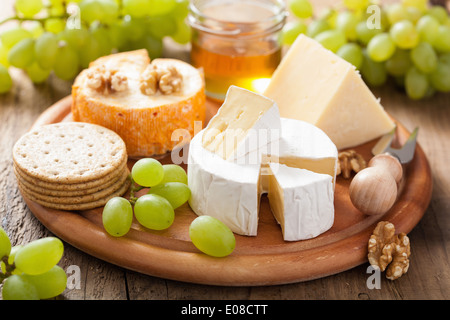 cheese plate with camembert, cheddar, grapes and honey Stock Photo