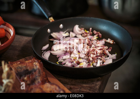 Onions and bacon in frying pan Stock Photo