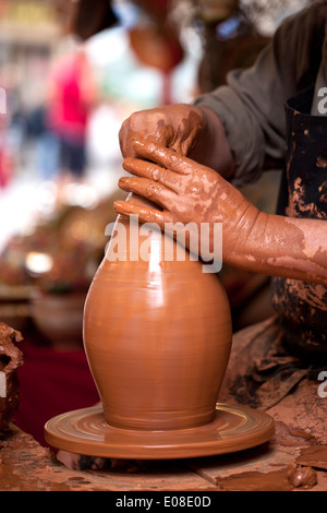 Hands of a potter creating a jar on the circle . Stock Photo