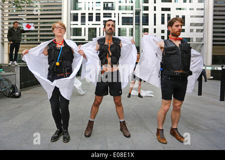 London, UK. 6th May 2014. Act Up Docs not Cops Immigration Bill protest at the Home Office in London with protestors dressed as doctors stripping off to become police. ACT UP London is fighting against two clauses in the Immigration Bill, which will serve to introduce charges for health services, turn doctors into border agents, and increase HIV infection. Credit:  Paul Brown/Alamy Live News Stock Photo