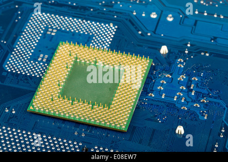 macro of computer processor on blue motherboard circuit Stock Photo