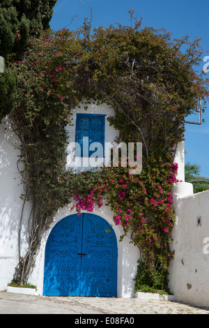 Sidi Bou Said, Tunisia 2014. Traditionally decorated bright blue door, white house and pink bougainvillea Stock Photo