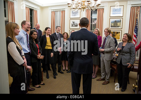 US President Barack Obama thanks White House and National Security Staff gathered in the Chief of Staff office for their work reviewing intelligence programs, in the West Wing of the White House January 17, 2014 in Washington, DC. Stock Photo
