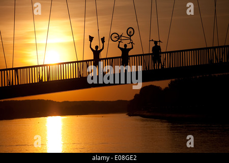Young people with BMX cycle, inline skates and skateboard on footbridge, Osijek, Croatia Stock Photo