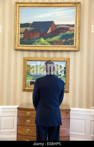 US President Barack Obama views Edward Hopper paintings on display in the Oval Office of the White House February 7, 2014 in Washington, DC. The paintings are Cobb's Barns, South Truro, top, and Burly Cobb’s House, South Truro. Stock Photo