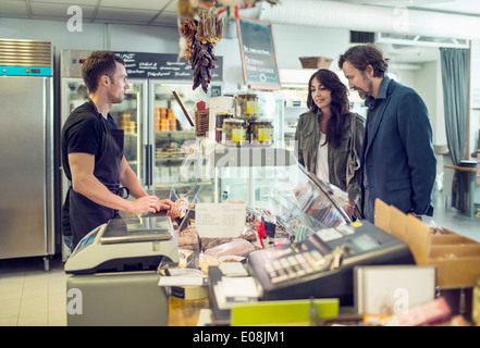 Salesman attending couple in supermarket Stock Photo