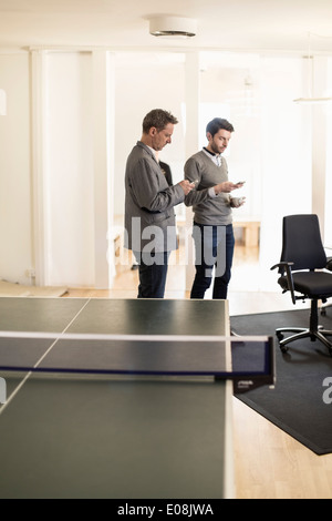 Businessmen using mobile phones in office Stock Photo