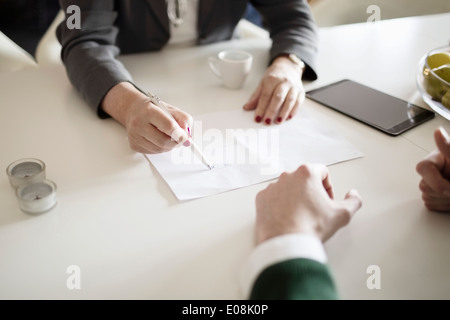 Cropped image of businesswoman drawing while explaining colleague at desk Stock Photo