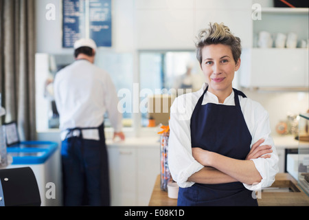 Portrait of confident female owner standing arms crossed in cafe Stock Photo