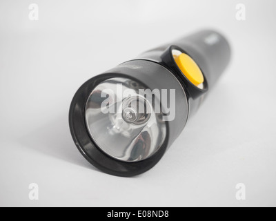 Black flashlight with yellow on/off button isolated on white background Stock Photo