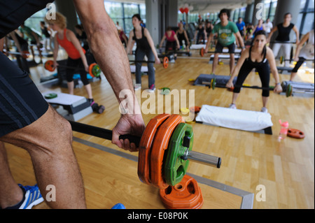 Fitness instructor's hand and barbell detail during a Body Pump class at the gym Stock Photo