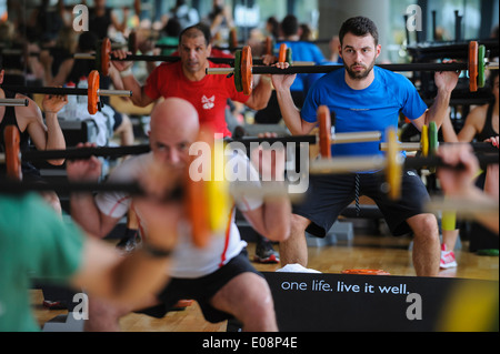 Young man doing squats during a Body Pump fitness class at the gym Stock Photo