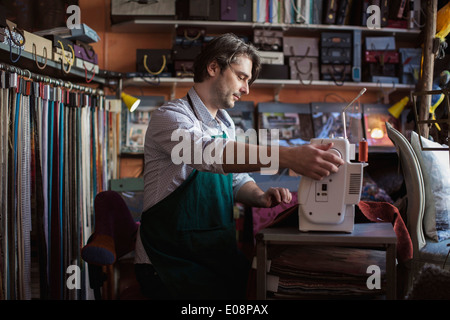 Male tailor using sewing machine in design studio Stock Photo