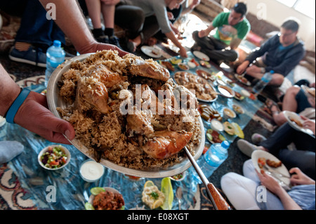A group of tourists having a traditional lunch with a local family in Orjan village near Al Ayoun trail. Jordan Stock Photo