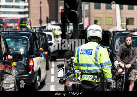 London, UK. 6th May 2014, A Metropolitan Motorcycle officer watches helplessly as taxis jam the streets of Southwark in protest over the refusal to place a Black Cab taxi rank outside the entrance to The Shard. Photographer:  Gordon Scammell/Alamy Live News Stock Photo