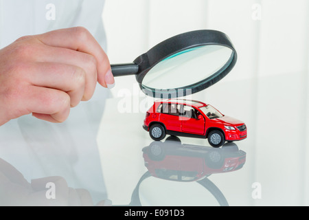 A model of a car is examined by a doctor. Symbolic photo fue workshop, service and autopurchase., Ein Modell eines Autos wird vo Stock Photo