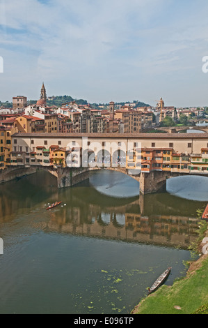 Il Ponte Vecchio or old bridge over the river Arno seen from rear of Uffizi Gallery Florence Italy with scullers rowing skiff Stock Photo