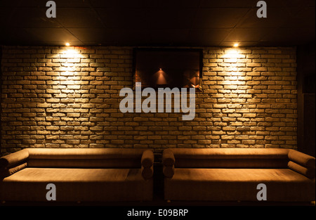 Old type brick wall texture front face and two sofa with local lighting Stock Photo