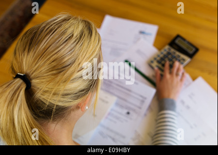 A woman with open calculations has many debts. Unemployment and private bankruptcy, Eine Frau mit offenen Rechnungen hat viele S Stock Photo