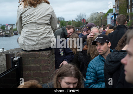 Spectators on the bank of the River Thames at Hammersmith during the annual Oxford and Cambridge Boat Race. Stock Photo