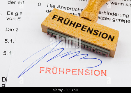 A stamp of wood lies on a document. German label: Early pension, Ein Stempel aus Holz liegt auf einem Dokument. Deutsche Aufschr Stock Photo